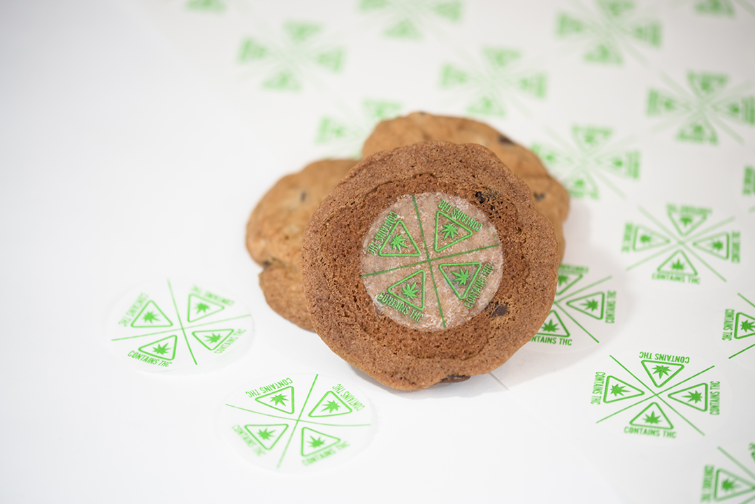 A cookie marked with an edible Contains THC symbol split 4 ways