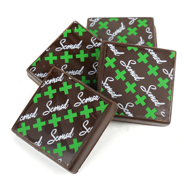 chocolate squares with the word "Sconed" and green crosses marked on them