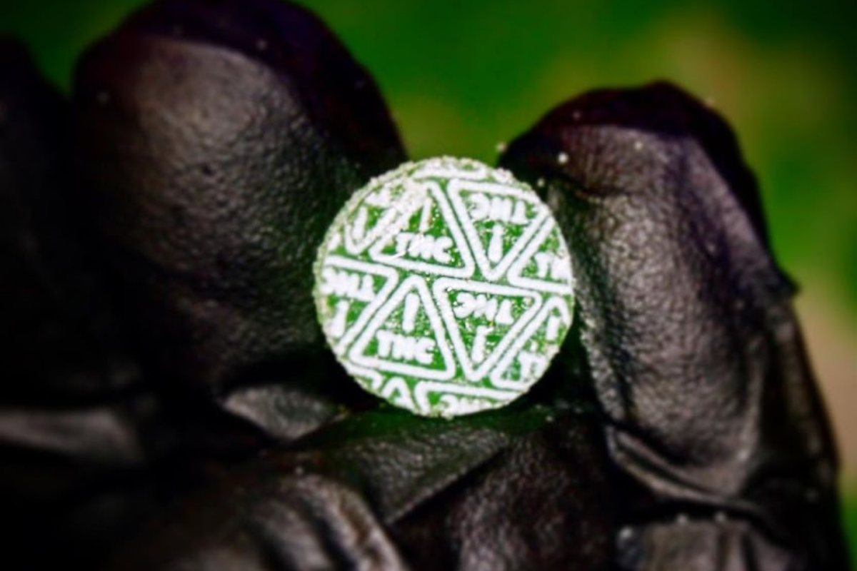 green gummy with white thc symbols on top