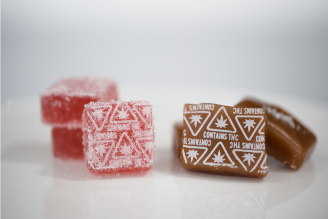 a caramel and gummy with massachusetts contains thc symbols in white embossed
